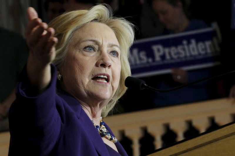 © Reuters. U.S. Democratic presidential candidate Hillary Clinton speaks in front of an audience member holding a sign in Boston