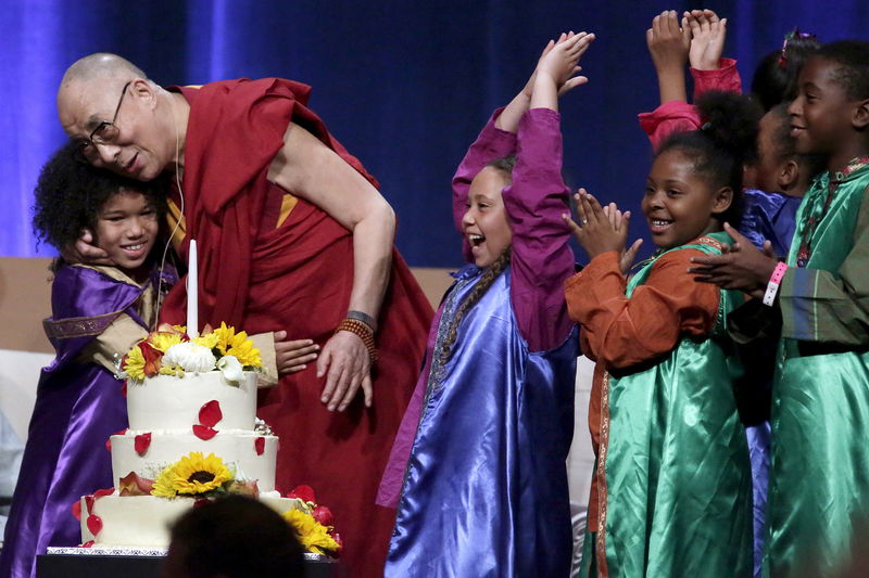 © Reuters. Children celebrate with the Dalai Lama after he blew out a candle on his birthday cake at the University of California, Irvine