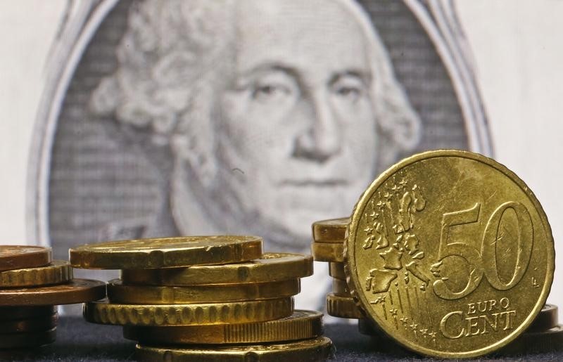 © Reuters. Monete in euro di fronte a una banconota da un dollaro Usa