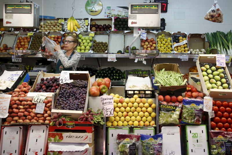 © Reuters. A vendor stands at a fruit and vegetable stand at the Barcelo market in Madrid, Spain