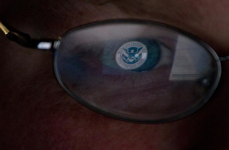 © Reuters. The logo of the U.S. Department of Homeland Security is reflected in the spectacles of an analyst working in a watch and warning center of a cyber security defense lab at the Idaho National Laboratory