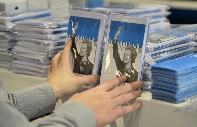 © Reuters. A stall holder arranges items for sale commemorating the late British Conservative Party Prime Minister Margaret Thatcher on the first day of the Conservative Party annual conference in Manchester