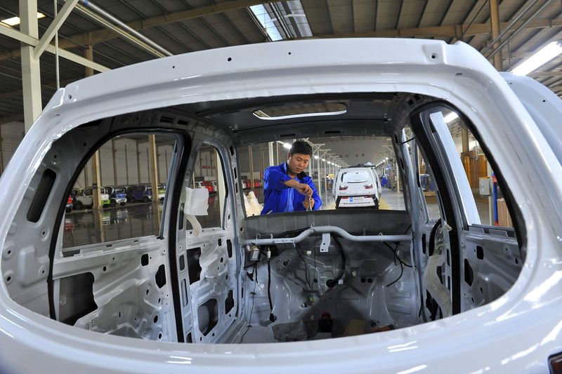 © Reuters. An employee assembles an electric car along a production line at a factory in Qingzhou