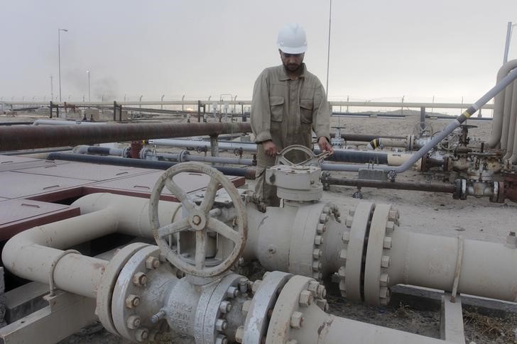 © Reuters. Рабочий крутит вентиль нефтепровода на месторождении Румайла к юго-востоку от Багдада