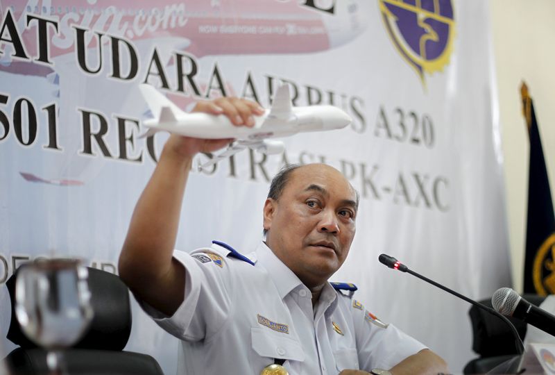 © Reuters. Soerjanto Tjahjono, the head of Indonesia's National Transportation and Safety Committee, holds a model plane during a news conference to announce the NTSC's findings in the investigation of the AirAsia QZ8501 crash, in Jakarta