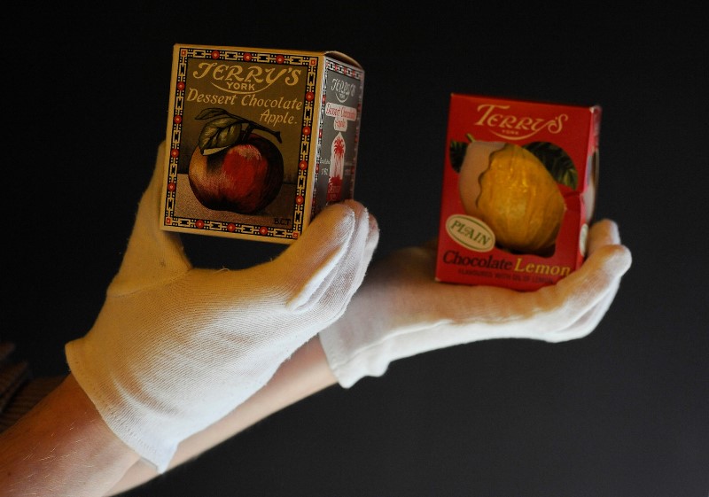 © Reuters. An assistant poses for a photograph with a Terry's chocolate apple 1929 and Lemon version 1980 at the Sweet Story in York