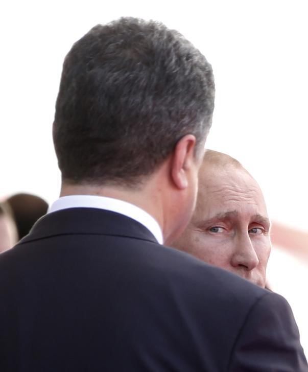 © Reuters. Президенты России и Украины Владимир Путин и Петр Порошенко на церемонии в Уистреаме 