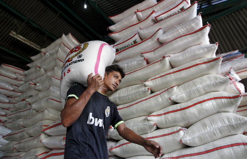 © Reuters. A worker carries a sack of rice at a wholesale rice market in East Jakarta