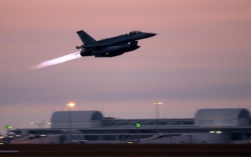 © Reuters. A Republic of Singapore air force F-16 fighter jet takes off at dusk from an air base near Darwin July 15, 2004