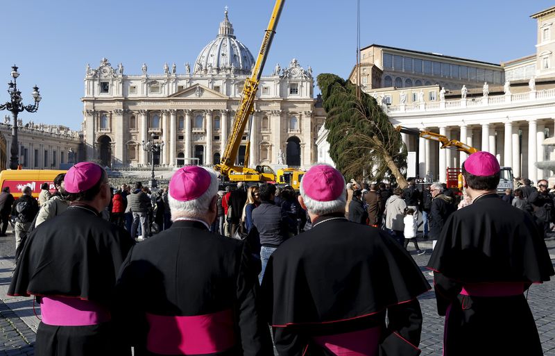 © Reuters. Vescovi a San Pietro osservano l'allestimento del tradizionale albero di Natale nella piazza 