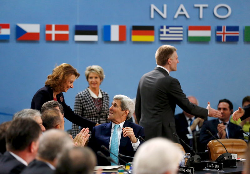 © Reuters. Il segretario di Stato Usa, John Kerry, saluta il ministro della Difesa del Montenegro Milica Pejanovic (S) mentre lei e il ministro degli Esteri Igor Luksic partecipano alla sessione di benvenuto del Montenegro a nuovo membro della NATO a Bruxelles.