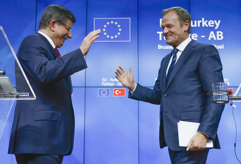 © Reuters. Turkish Prime Minister Ahmet Davutoglu and European Council President Donald Tusk greet each other after a news conference following a EU-Turkey summit in Brussels, Belgium 