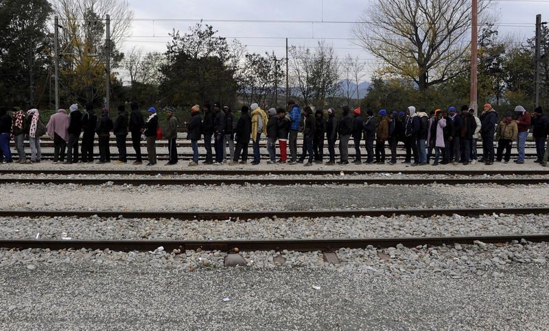 © Reuters. Stranded migrants line up for a food distribution at the Greek-Macedonian border, near the village of Idomeni