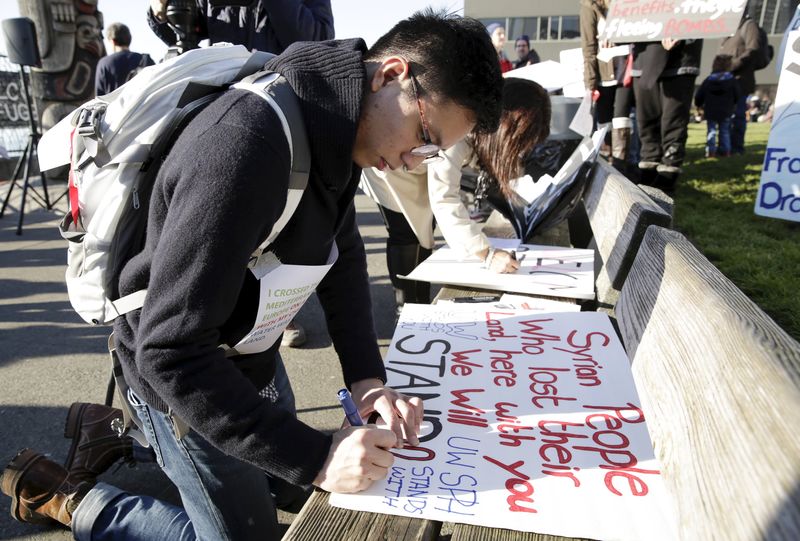 © Reuters. University of Washington student William Tsang, 22, of Vancouver, Canada makes a sign at a pro-refugee protest organized by Americans for Refugees and Immigrants in Seattle, Washington