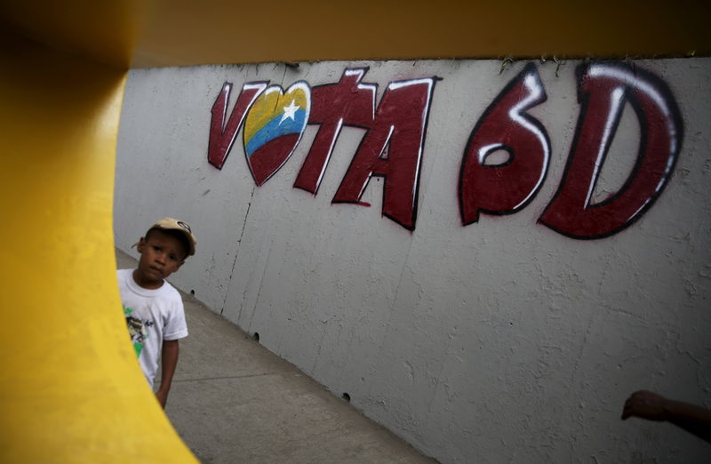 © Reuters. Menino passa por grafiti de campanha em Caracas 