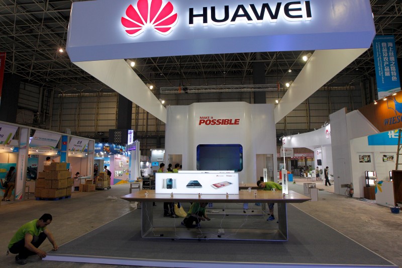 © Reuters. Workers prepare the stand for Huawei at the venue of the 21st Century Maritime Silk Road International Expo in Dongguan