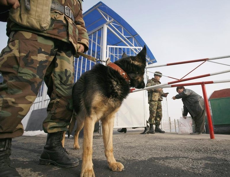 © Reuters. Kyrgyz border guards check man's documents at a checkpoint in a village of Karasuu