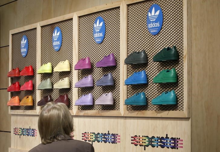 © Reuters. A shareholder of Adidas, the world's second largest sports apparel firm, looks at shoes during the company annual general meeting in the northern Bavarian town of Fuerth
