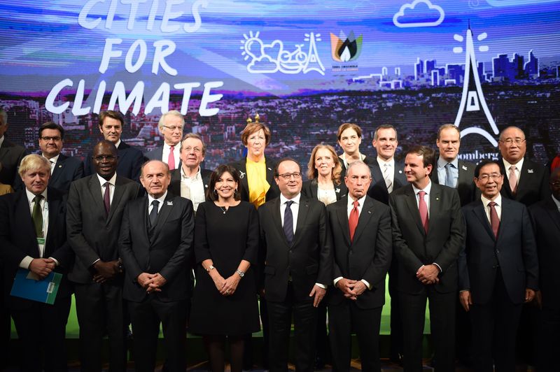 © Reuters. French President Hollande poses with local representatives as he attends a summit on climat with local representatives at Paris town hall