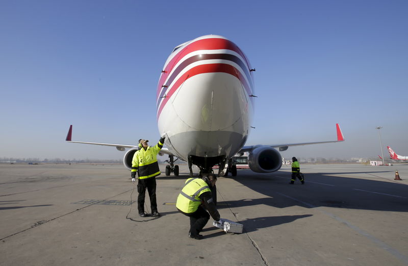 © Reuters. Members of the ground service crew check a China United Airlines aircraft after it landed at the Nanyuan Airport in Beijing