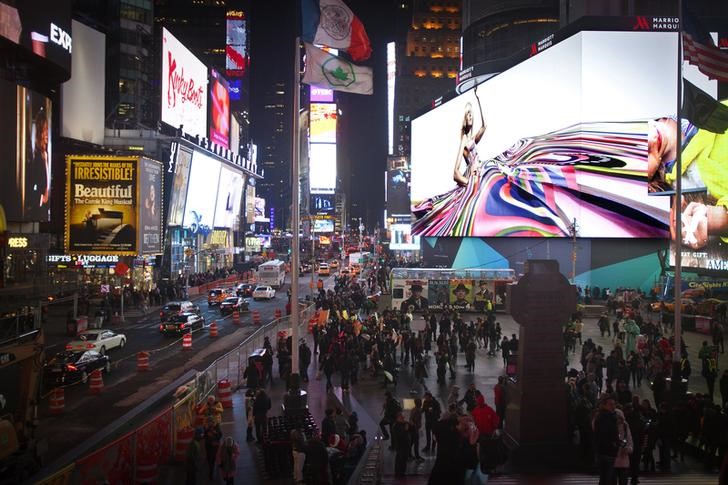 © Reuters. People walk underneath a giant new advertising screen in Times Square, New York