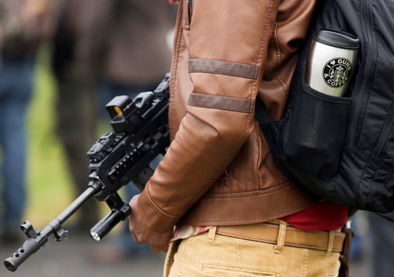 © Reuters. Williams holds a firearm as he attends a rally against Initiative 594 at the state capitol in Olympia, Washington