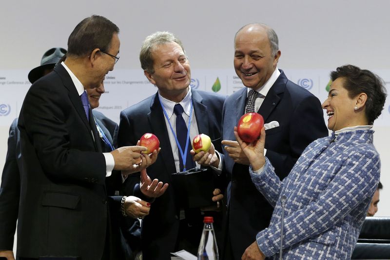 © Reuters. French Foreign Minister Laurent Fabius, UN Secretary General Ban Ki-moon and Executive Secretary of the UN Framework Convention on Climate Change Christiana Figueres hold apples during the World Climate Change Conference 2015 at Le Bourget