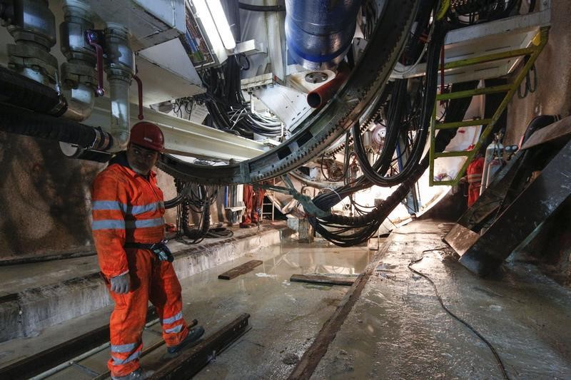 © Reuters. A worker stands next to a drill machine in the tunnel of a high-speed train line which will link Turin in northern Italy to Lyon in France, through the Val di Susa in Chiomonte