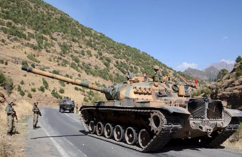 © Reuters. Turkish soldiers in a tank and an armored vehicle patrol on the road to the town of Beytussebab in the southeastern Sirnak province, Turkey