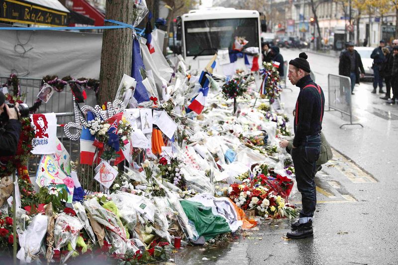 © Reuters. LES EAGLES OF DEATH METAL SE RECUEILLENT DEVANT LE BATACLAN