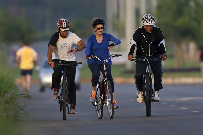 © Reuters. Brazil's President Dilma Rousseff rides her bicycle near the Alvorada Palace in Brasilia