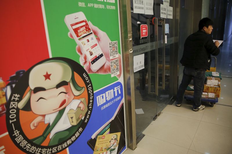 © Reuters. A delivery man stops in front of doors of the Beijing offices of Shequ001, a start-up company delivering supermarket goods booked via smartphone