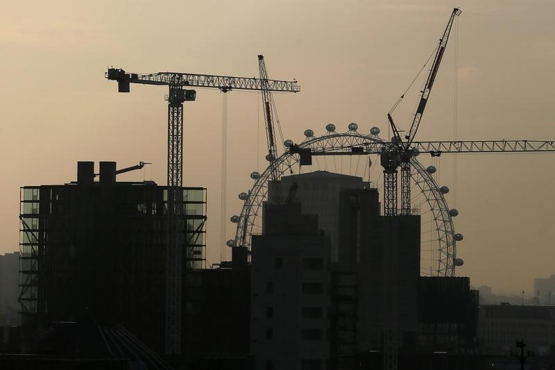 © Reuters. The London Eye is seen behind cranes in central London