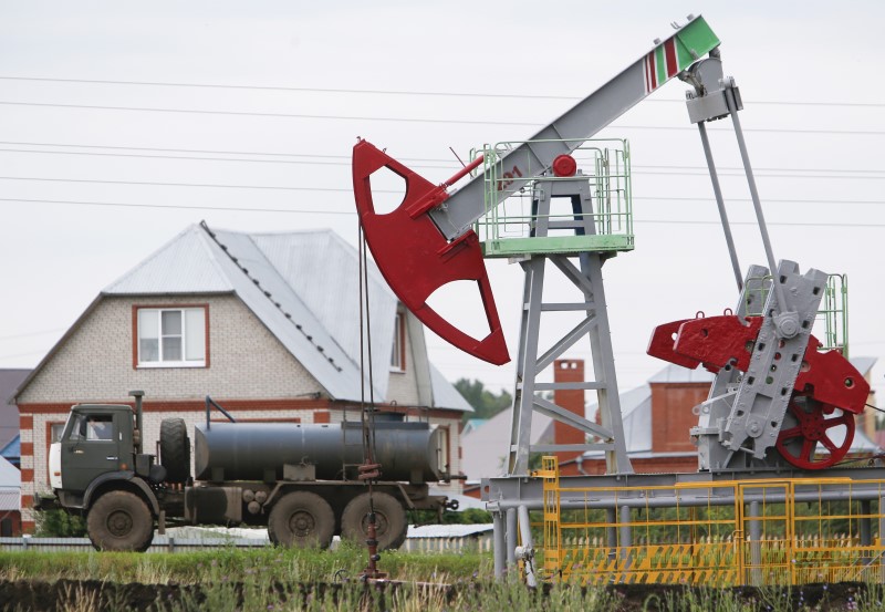 © Reuters. A fuel tanker truck drives past a pump jack at an oil field Sergeyevskoye owned by Bashneft company north from Ufa