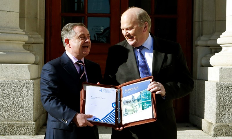 © Reuters. Ireland's Finance Minister Noonan stands with Minister for Public Expenditure Howlin as they present the budget to media at the Government Buildings in Dublin