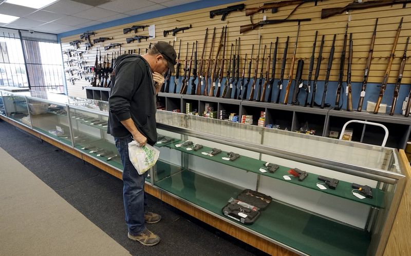 © Reuters. A customer looks over weapons for sale at the Pony Express Firearms shop in Parker 