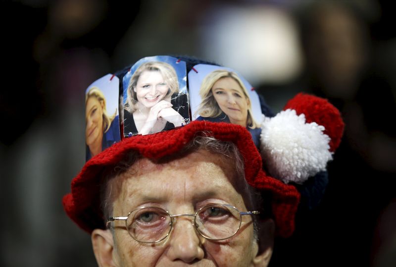 © Reuters. A supporter wears a cap with pictures of Marine Le Pen and Marion Marechal-Le Pen, French National Front political party candidates for the second round of the regional elections in Marseille