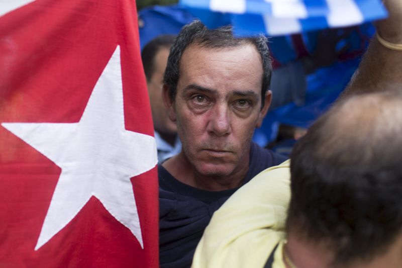 © Reuters. A supporter of the Ladies in White dissident group looks on as he is detained by Cuban security personnel during a protest on International Human Rights Day, Havana