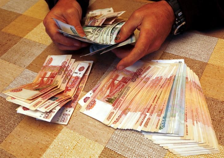 © Reuters. A local businessman counts Russian roubles at a tourist base outside Krasnoyarsk