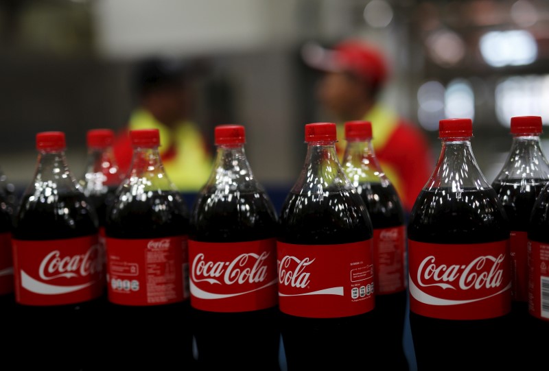 © Reuters. Workers stand near bottles of Coca-Cola on a newly inaugurated production line at the Cikedokan Plant in Bekasi, West Java near Jakarta 