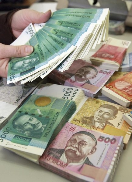 © Reuters. A cashier counts Kyrgyzstan's Som currency banknotes at the National bank in Bishkek