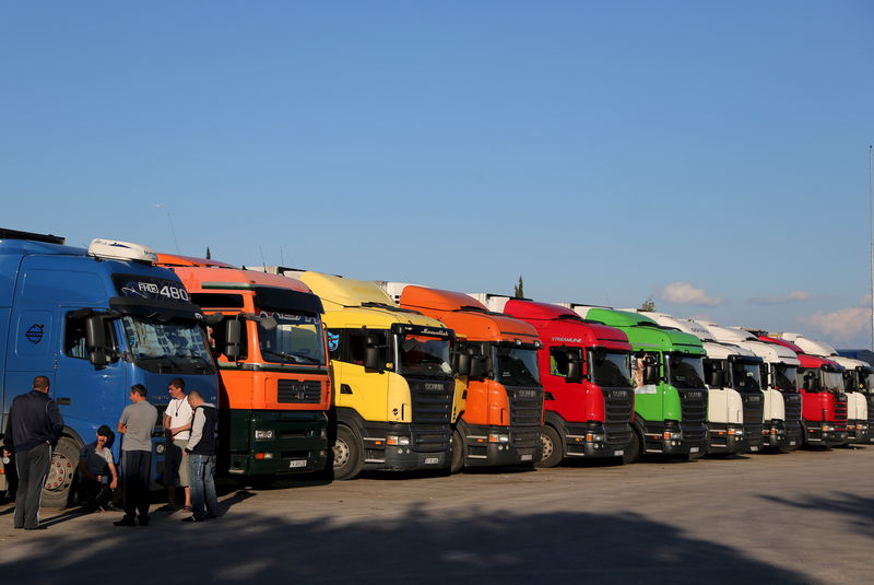 © Reuters. Drivers chat while waiting for their trucks to be loaded with fresh fruits and vegetables at a wholesale market in the Mediterranean resort city of Antalya