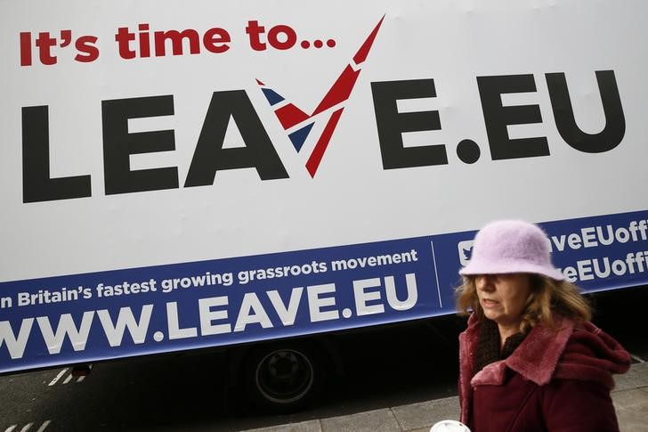 © Reuters. A woman walks past a Leave.EU campaign mobile advertising board in central London