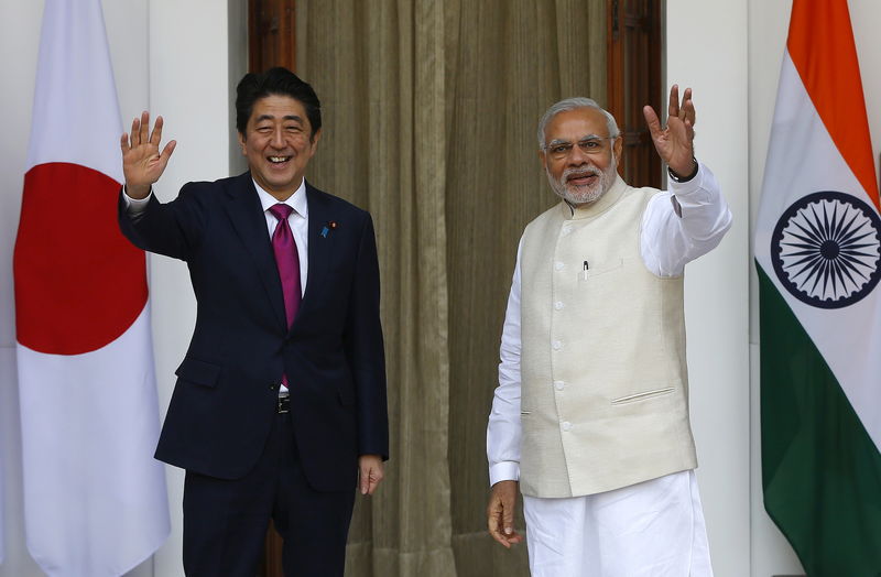 © Reuters. Japan's Prime Minister Abe and his Indian counterpart Modi wave during a photo opportunity ahead of their meeting at Hyderabad House in New Delhi