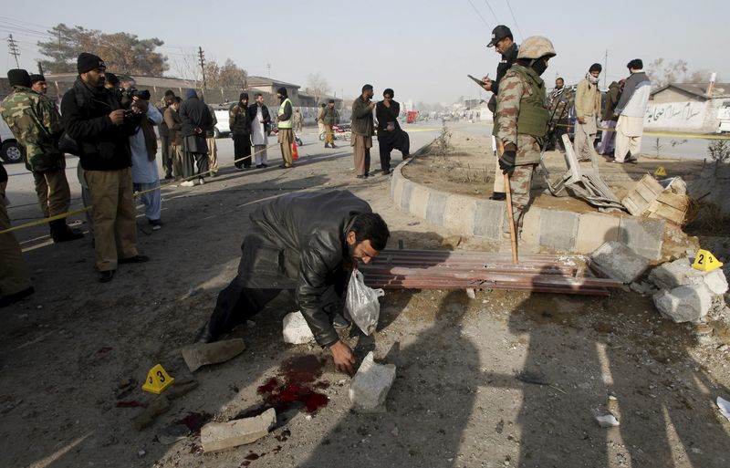 © Reuters. A security official collects evidence at a bomb blast site near a checkpost in Quetta, Pakistan