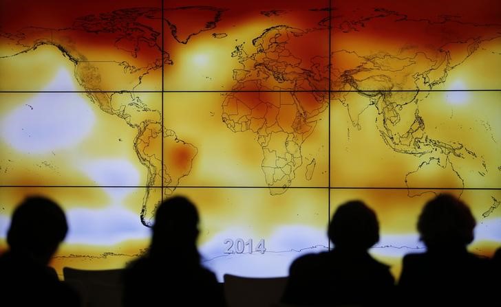 © Reuters. Participants looks at a screen projecting a world map with climate anomalies during the World Climate Change Conference 2015 (COP21) at Le Bourget