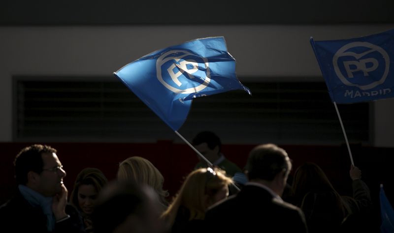 © Reuters. People's Party (PP) supporters wave flags during a campaign rally in Las Rozas