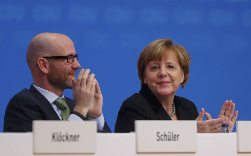 © Reuters. Germany's CDU secretary general Tauber and German Chancellor and leader of the CDU Merkel applaud after a vote on a resolution about refugees at the CDU party congress in Karlsruhe