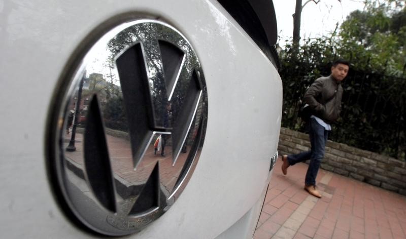 © Reuters. A man walks past a Volkswagen Touran along a busy street in downtown Shanghai