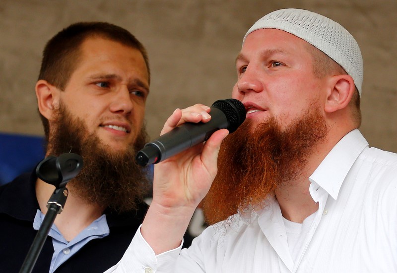 © Reuters. Islamic preachers Pierre Vogel and Sven Lau from Germany talk to their supporters during the "Islamic Peace Congress" in Frankfurt